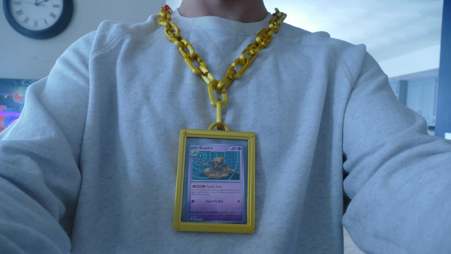 Person wearing yellow 3D printed chain necklace displaying a collectible card in frame