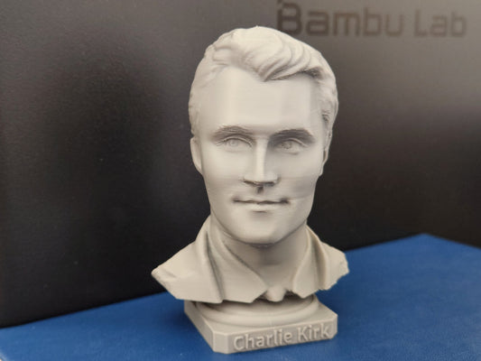 3D printed bust sculpture of Charlie Kirk in light gray with detailed facial features and engraved base