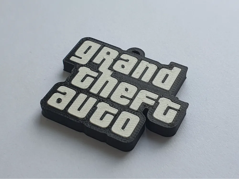 3D printed 'grand theft auto' logo keychain with white letters and black border