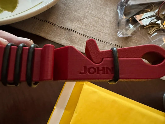 Red 3D printed clip-on cigar holder attached to a hand, designed for golf cart tubing