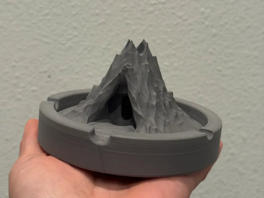 3D printed volcano-shaped ashtray held in hand showing detailed textured design and gray plastic material