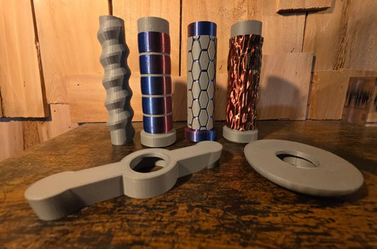 3d printed modular pool noodle sword parts including three distinct handles and two different hand guards laid out on wood surface